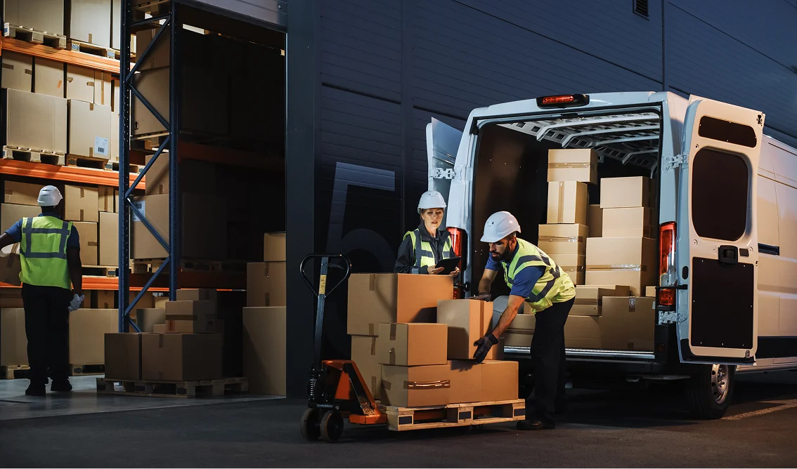 GettyImages-512891486 1 Workers loading boxes into delivery van.